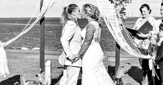 Black and white seaside ceremony kiss