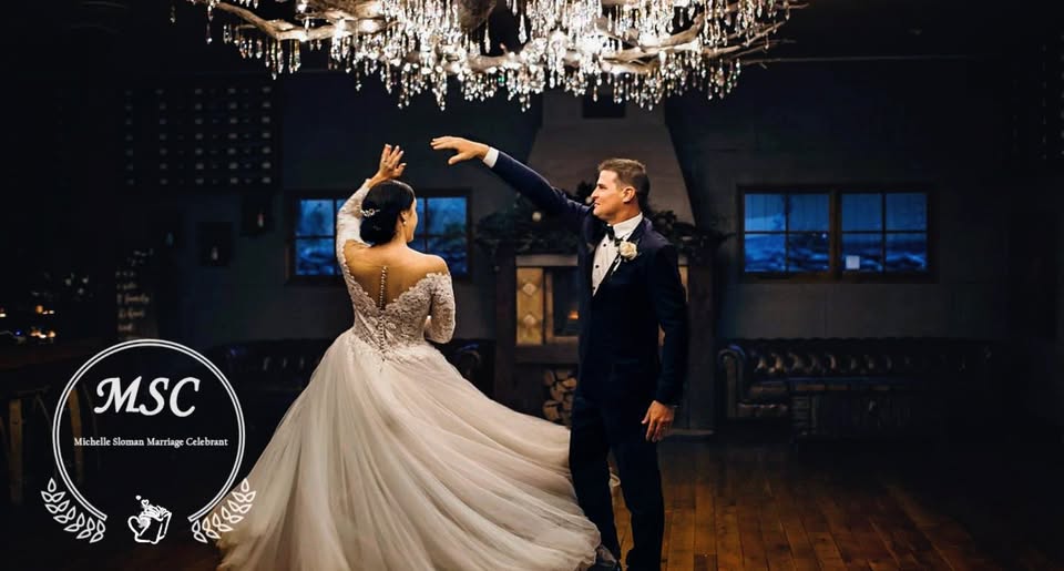 Bride and groom first dance under chandelier
