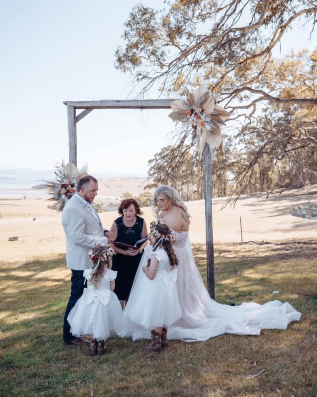 Outdoor ceremony with pampas grass arch